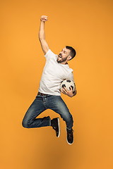 Image showing The young man as soccer football player kicking the ball at studio