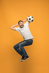 Image showing The young man as soccer football player kicking the ball at studio