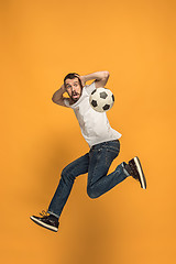 Image showing The young man as soccer football player kicking the ball at studio