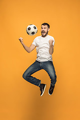 Image showing The young man as soccer football player kicking the ball at studio