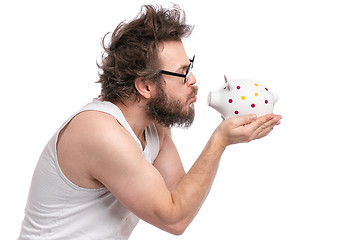 Image showing Crazy bearded man with piggy bank