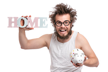 Image showing Crazy bearded man with piggy bank