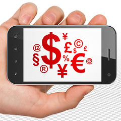 Image showing Advertising concept: Hand Holding Smartphone with Finance Symbol on display