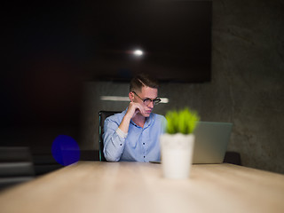 Image showing man working on laptop in dark office