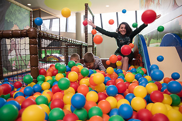 Image showing Young mom with her kids in a children\'s playroom