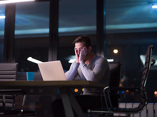 Image showing man working on laptop in dark office