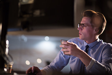 Image showing man using mobile phone in dark office