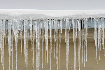 Image showing Big icicles hang from the roof of a house.