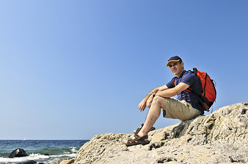 Image showing Hiker sitting on a rock