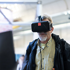 Image showing Senior man wearing virtual reality goggles watching virtual reality presentation.