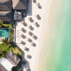 Image showing Aerial view of amazing tropical white sandy beach with palm leaves umbrellas and turquoise sea, Mauritius.