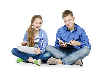 Image showing Teen age boy and girl with tablet and notebook