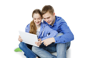 Image showing Teen boy and girl sitting with tablets