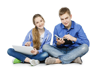 Image showing Teen age boy and girl with tablet and notebook