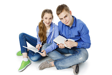 Image showing Teen age boy and girl with tablet and notebook