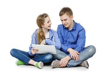 Image showing Teen boy and girl sitting with tablets