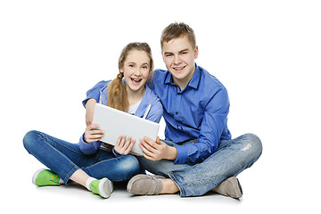 Image showing Teen boy and girl sitting with tablets