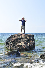 Image showing Man stranded on a rock in ocean