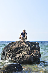 Image showing Man stranded on a rock in ocean