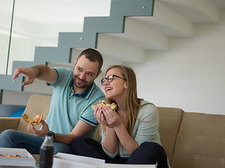 Image showing couple eating pizza in their luxury home villa