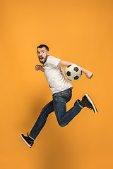 Image showing The young man as soccer football player kicking the ball at studio