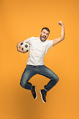 Image showing The young man as soccer football player kicking the ball at studio