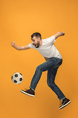 Image showing The young man as soccer football player kicking the ball at studio