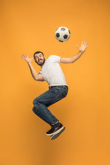 Image showing The young man as soccer football player kicking the ball at studio