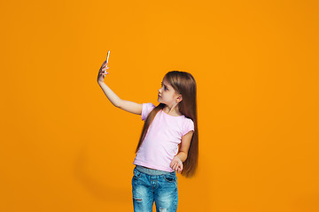 Image showing The happy teen girl standing and smiling with phone