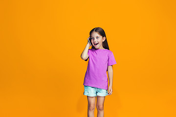 Image showing The happy teen girl standing and smiling with phone