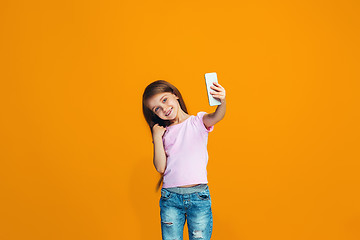 Image showing The happy teen girl standing and smiling with phone