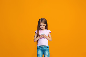 Image showing The happy teen girl standing and smiling with phone