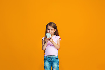 Image showing The happy teen girl standing and smiling with phone