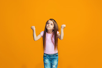 Image showing Portrait of angry teen girl on a orange studio background