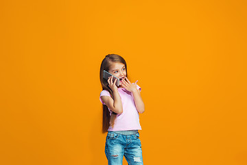 Image showing The happy teen girl standing and smiling with phone