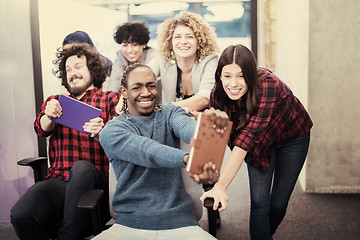 Image showing multiethnics business team racing on office chairs