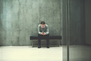 Image showing businessman using smart phone while sitting on the bench