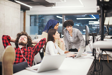 Image showing software developer resting with legs on desk