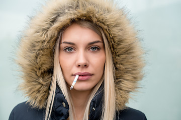 Image showing portrait of young blonde girl with cigarette in the mouth