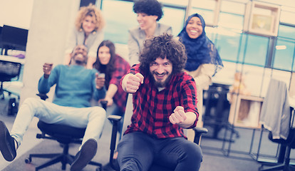 Image showing multiethnics business team racing on office chairs