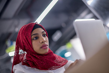 Image showing black muslim business woman ,working on laptop computer