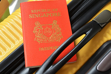 Image showing Singapore passport on a yellow suitcase