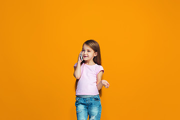 Image showing The happy teen girl standing and smiling with phone