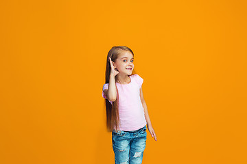 Image showing The young teen girl whispering a secret behind her hand