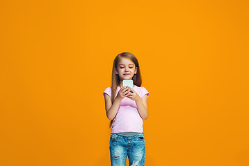 Image showing The happy teen girl standing and smiling with phone