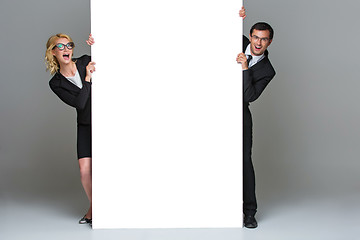 Image showing Businessman and business woman with big empty poster