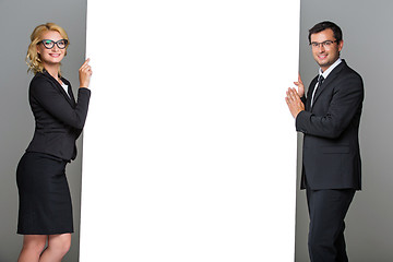 Image showing Businessman and business woman with big empty poster