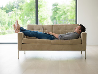 Image showing Man using laptop in living room