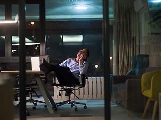 Image showing businessman using mobile phone in dark office