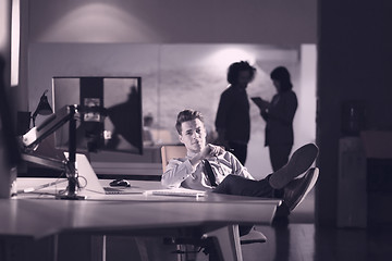 Image showing businessman sitting with legs on desk at office